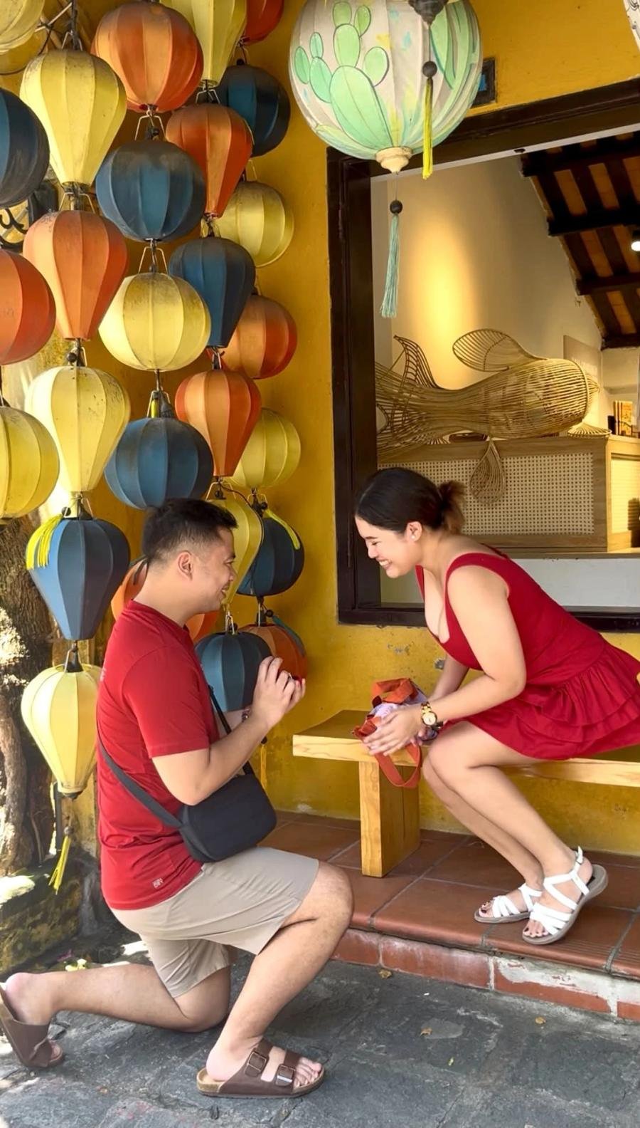 Nelson on one knee proposing to Chanel beneath the lanterns of Hoi An